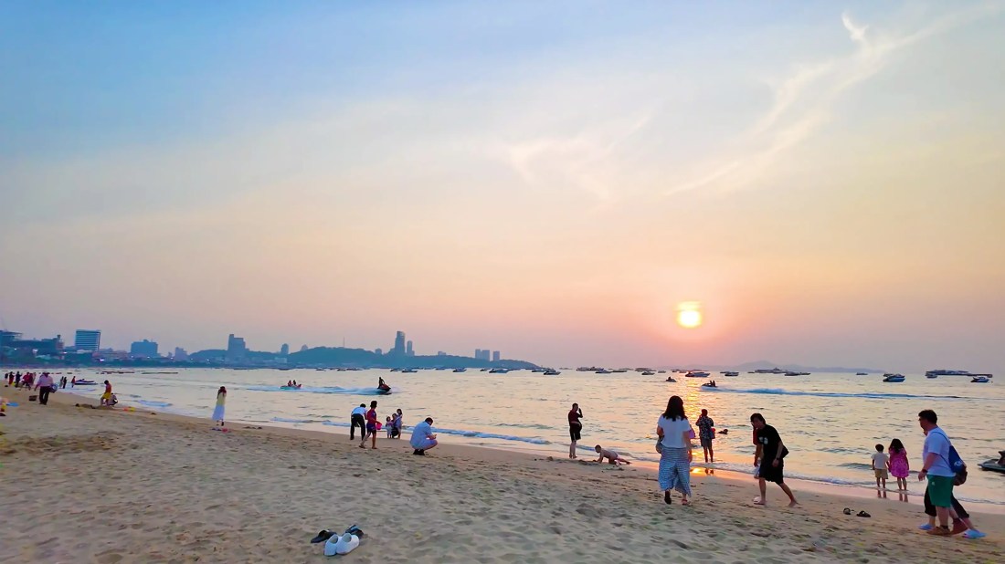 Thai family and friends playing on Pattaya Beach during beautiful sunset