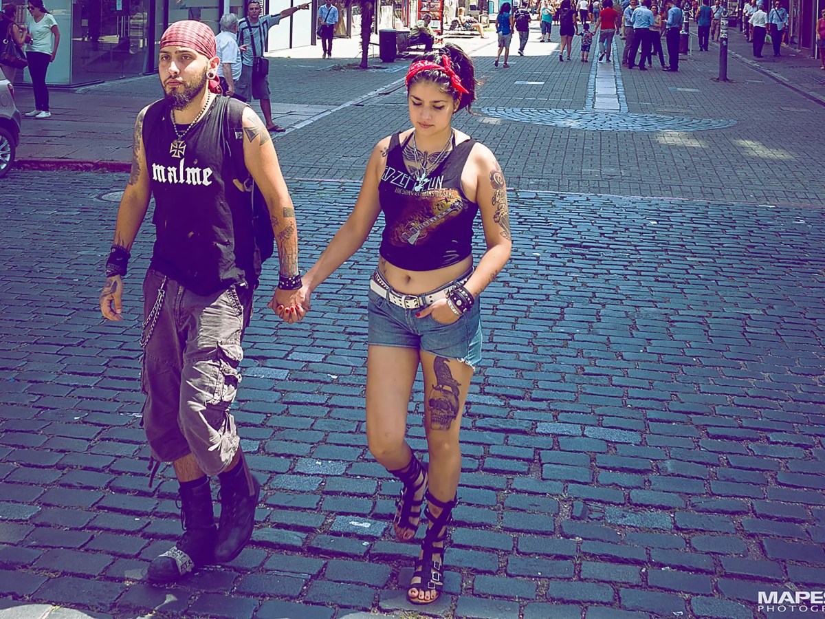a young Uruguayan couple with tattoos holding hands, walking in Montevideo, Uruguay