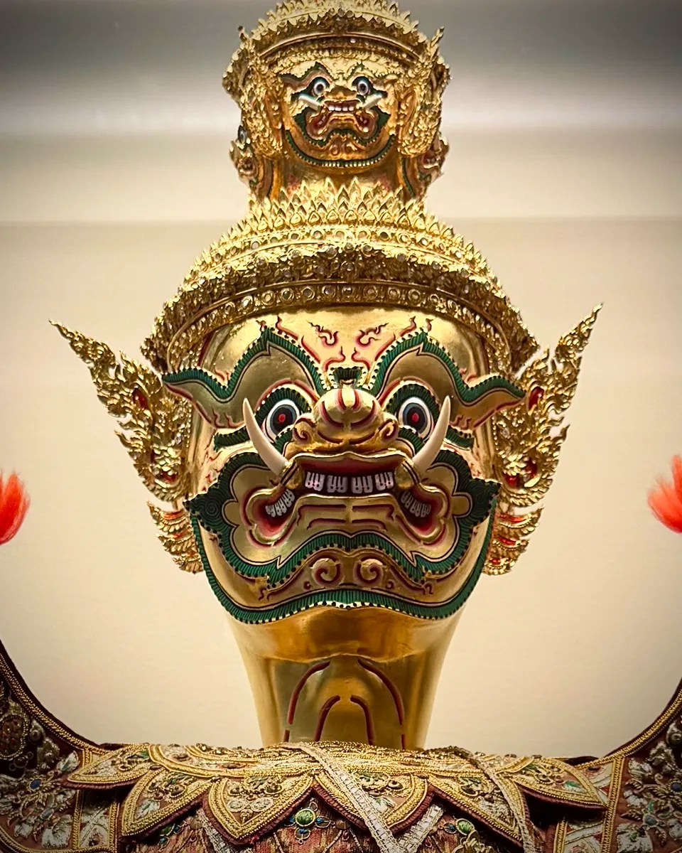 a gold and green traditional khon demon mask